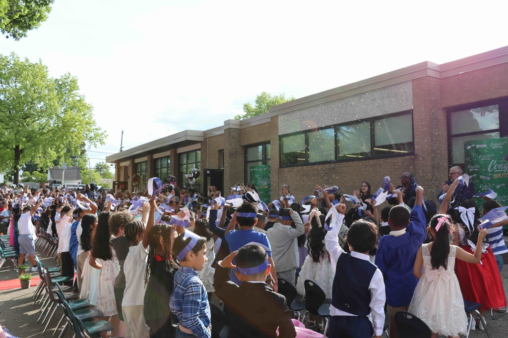 Confetti falls over the students as they celebrate.