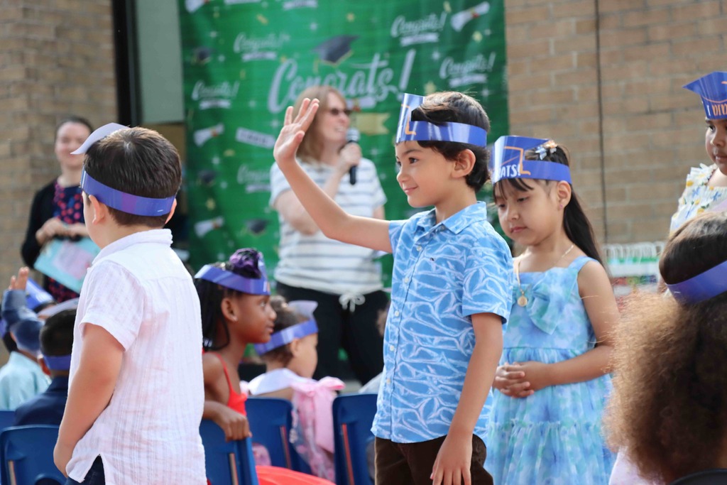 A student waves to family members.