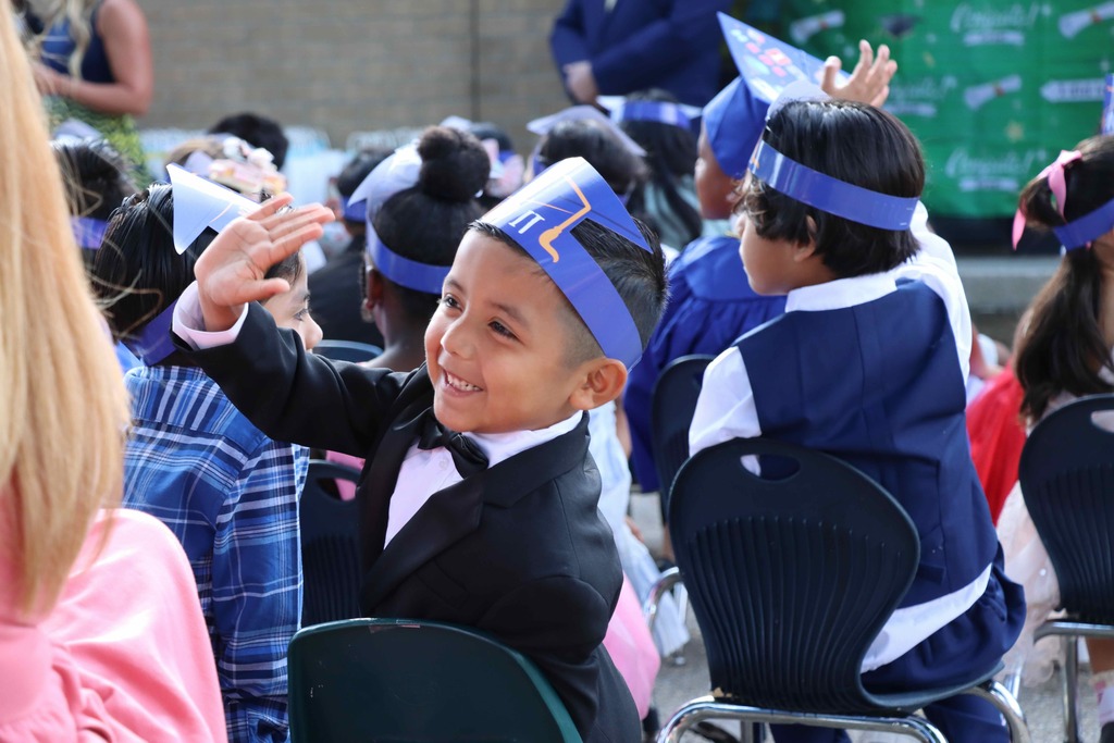 A student waves to family members.