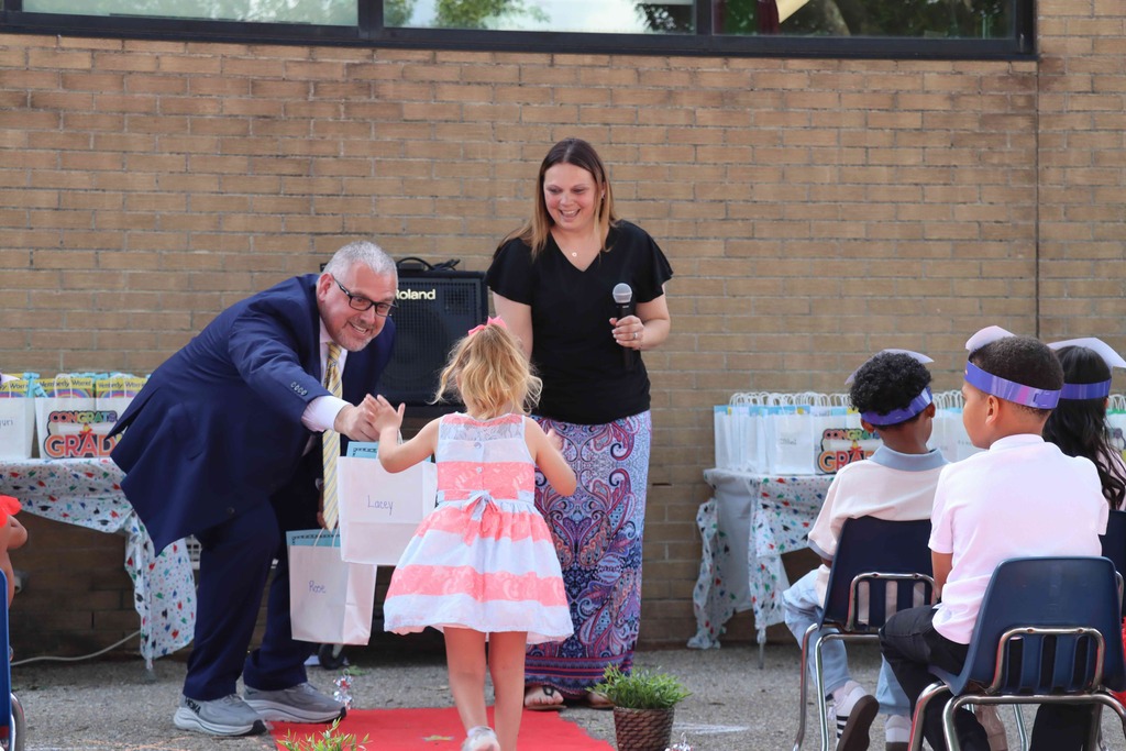 A student high fives Mr. Dormer, NASD's Superintendent.