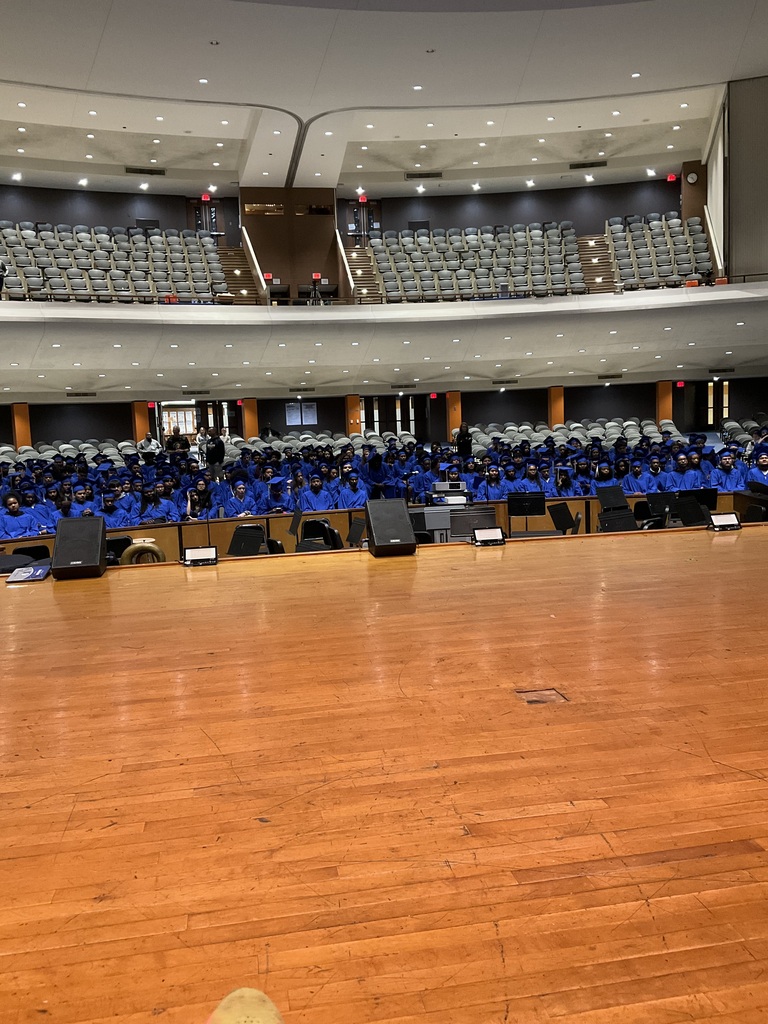 Students are in their lap and gowns in the auditorium