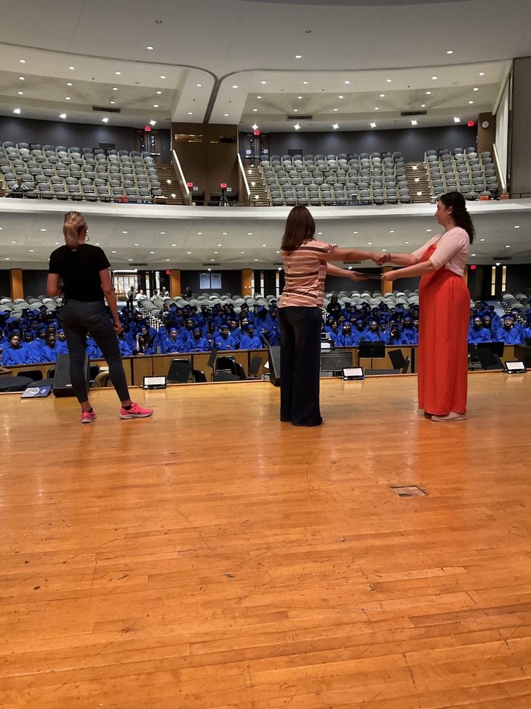 Staff members are showing how to receive a diploma on stage