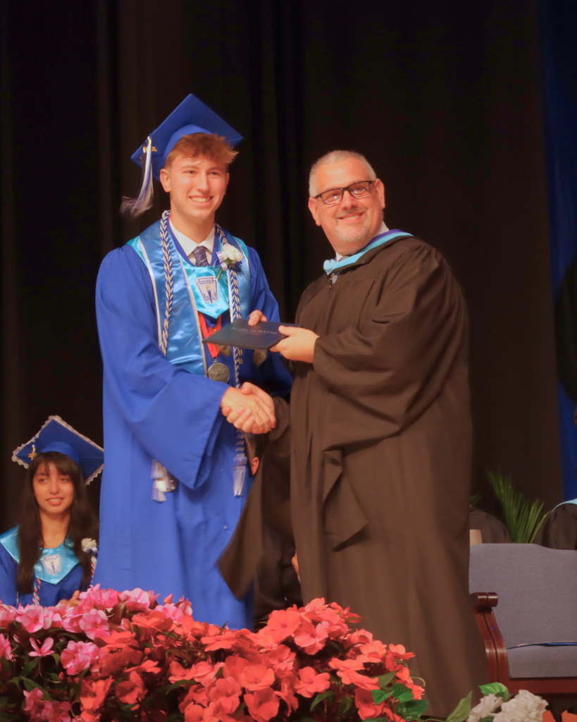 Graduate receiving their diploma on stage.