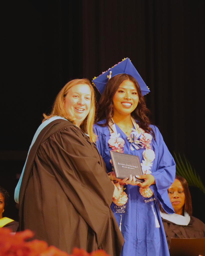 Graduate receiving their diploma on stage.
