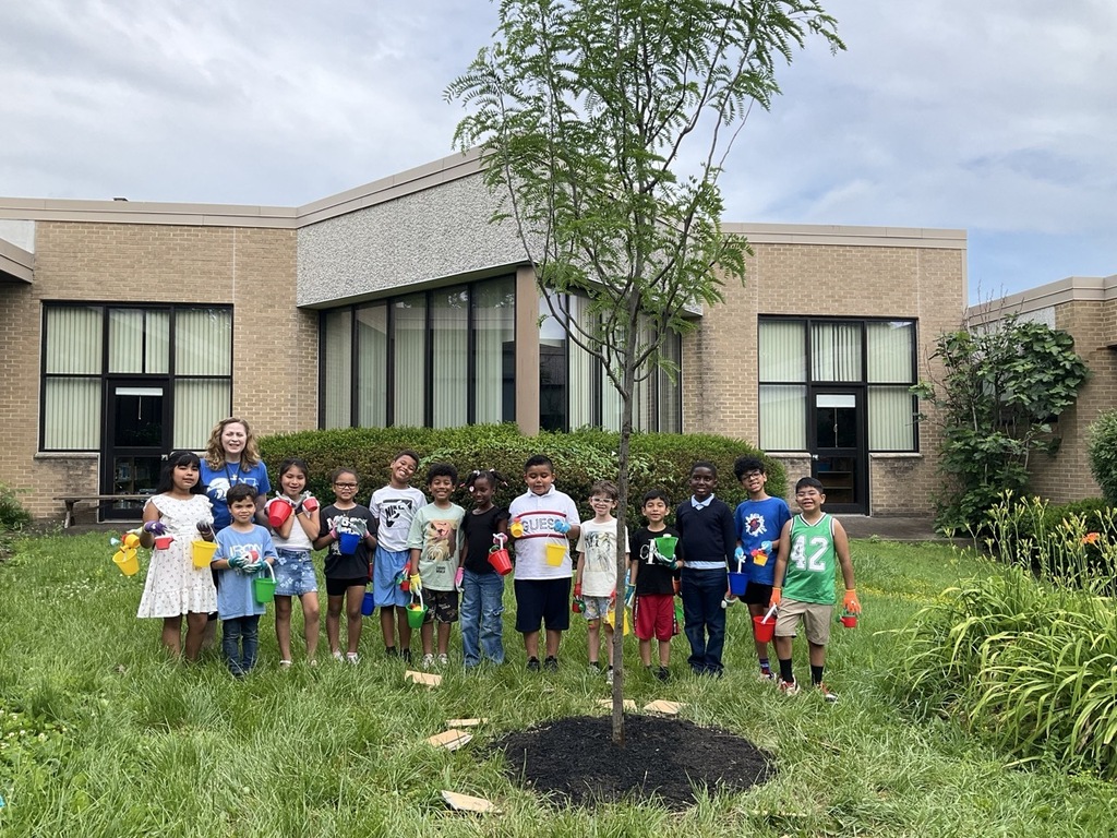 Mrs. Krause's class poses for a photo after watering our new Honey Locust tree.