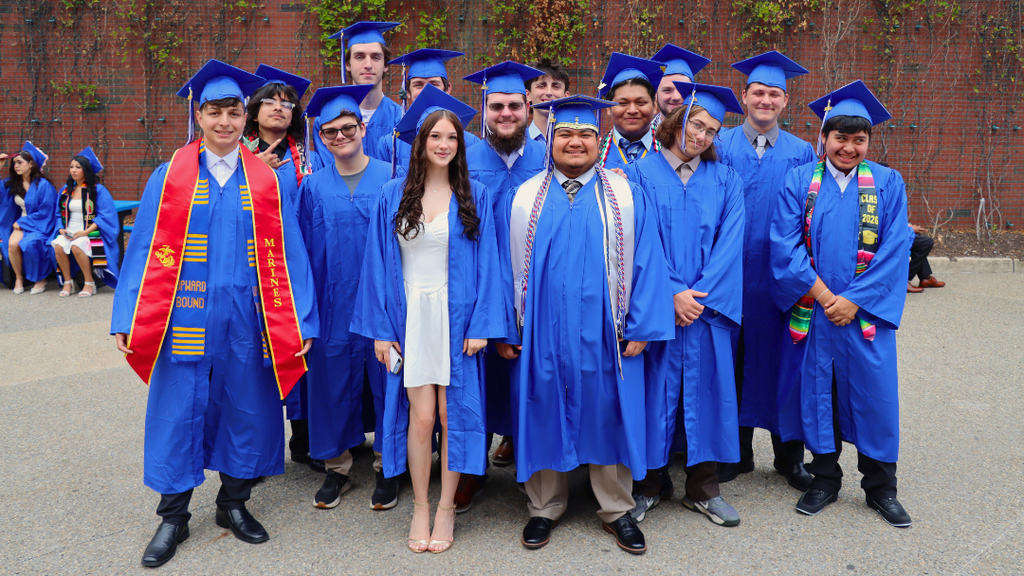 Group pf graduates pose for photo before checking in for graduation.