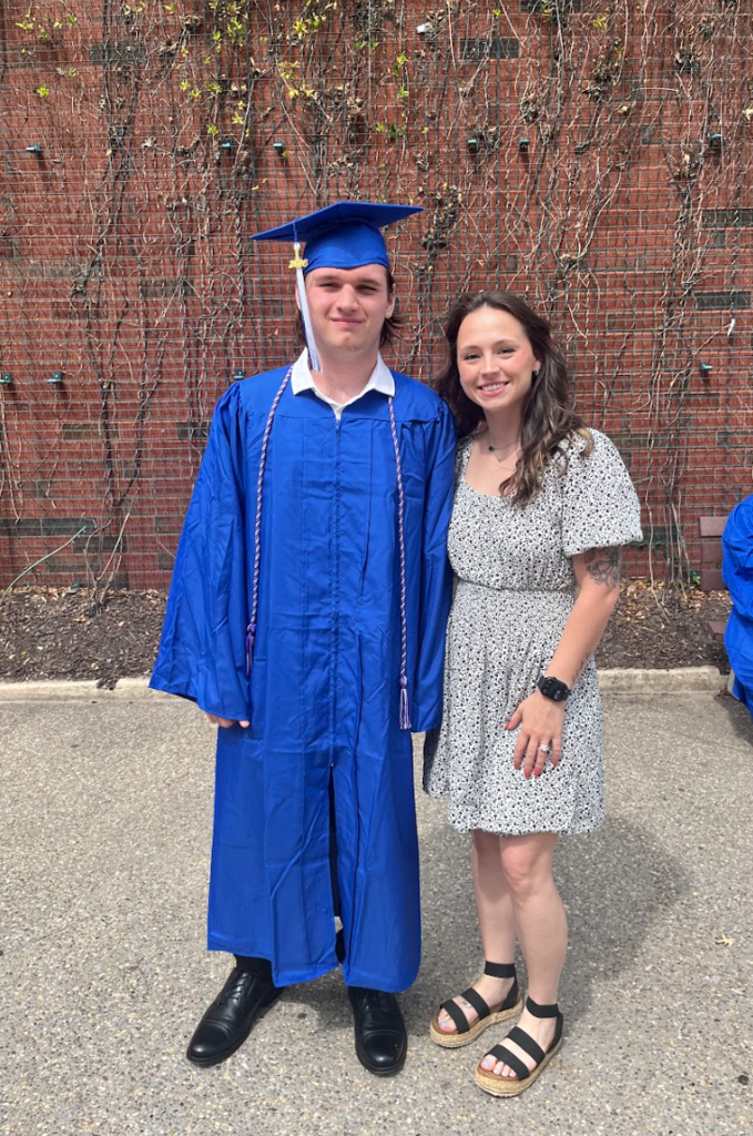 A teacher and student are posing together 