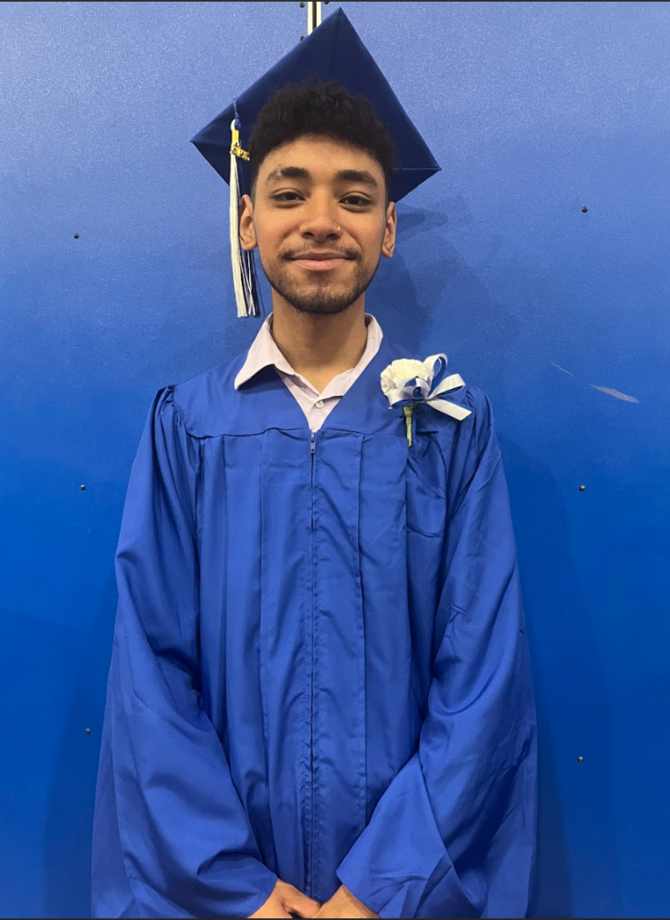 A student is posing with his cap and gown 