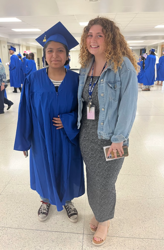 A student and teacher are posing together 