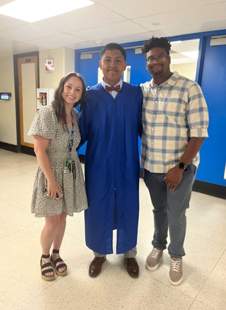 Two teachers and a student are posing together for a graduation picture