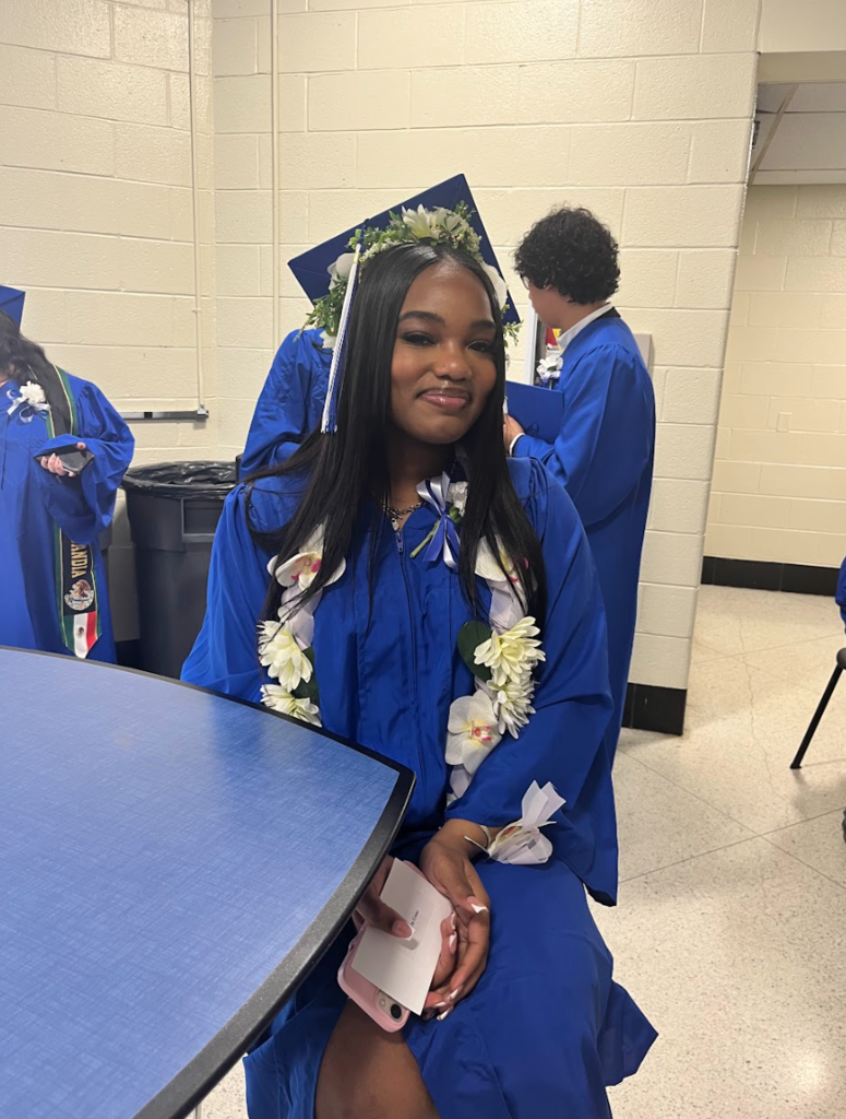 A girl is posing in her chair in a cap and gown 