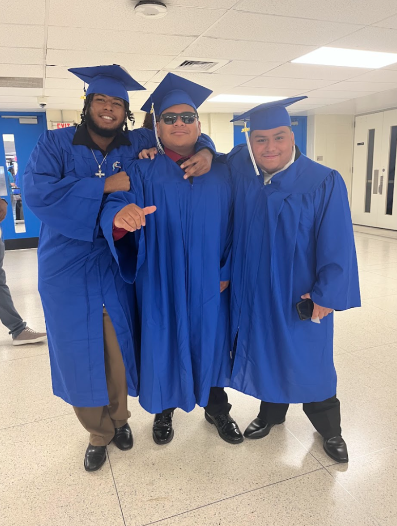 three boys are posing in their cap and gowns 