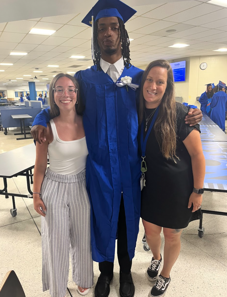 Two teachers and a student are posing together 