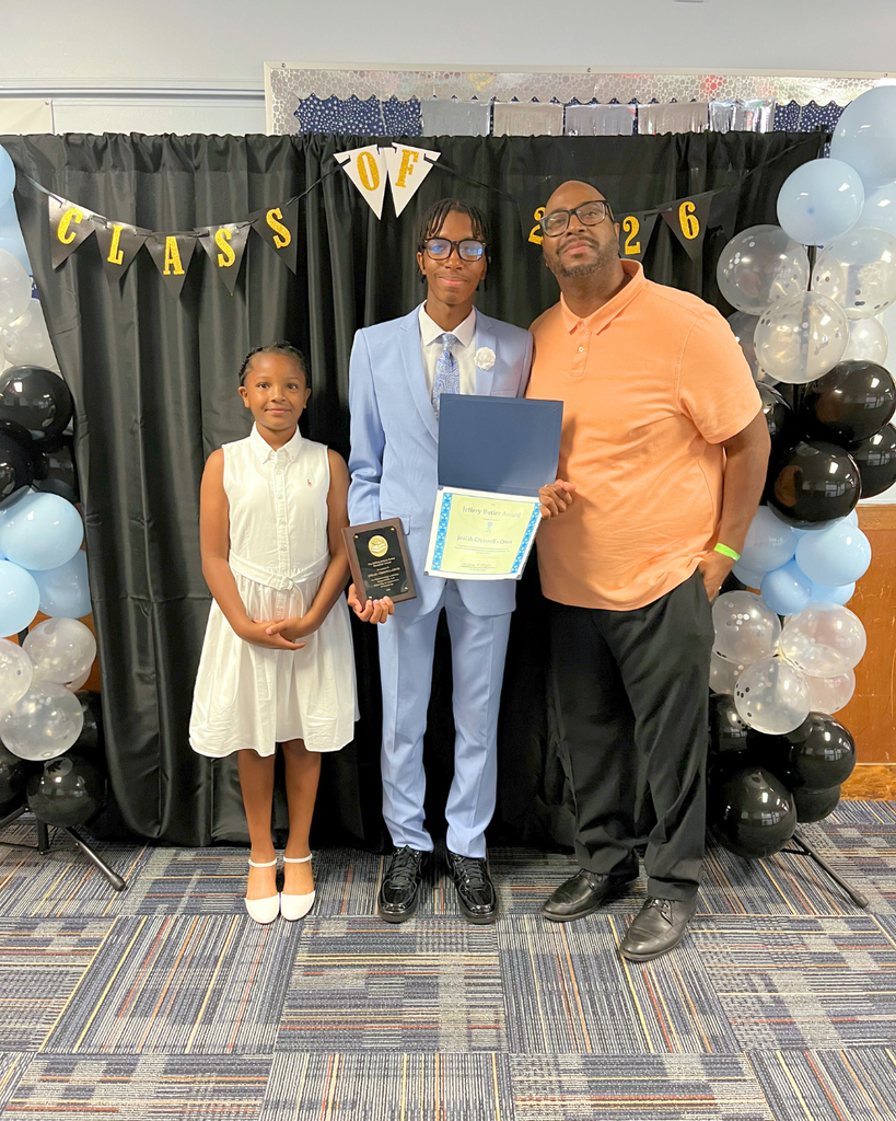 8th grade graduate poses for photo with family.