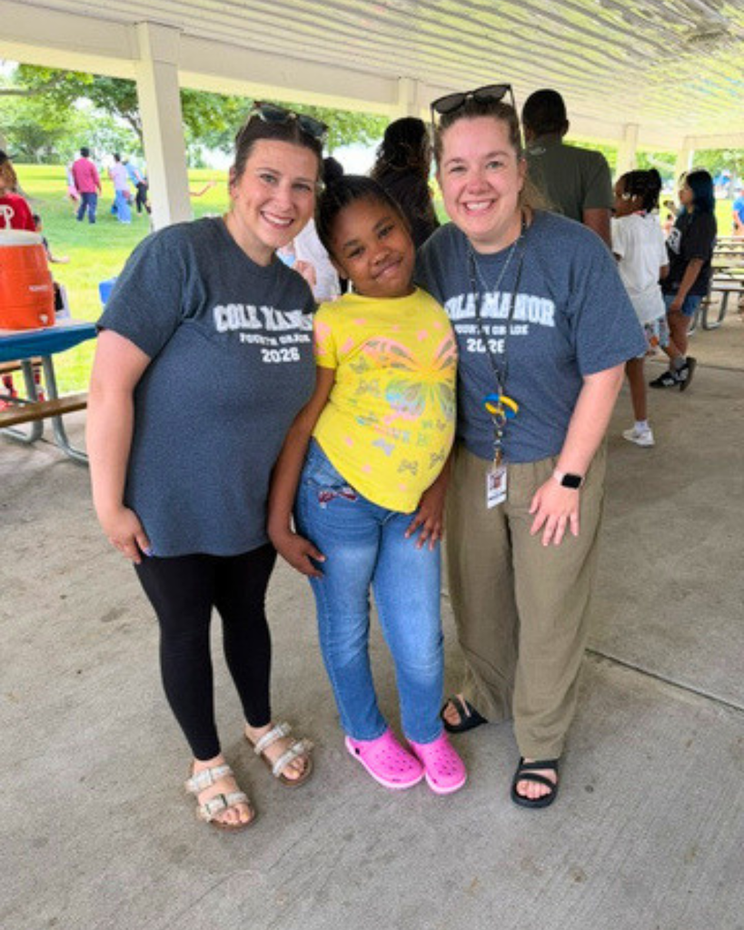 Student poses for photo with two staff members.