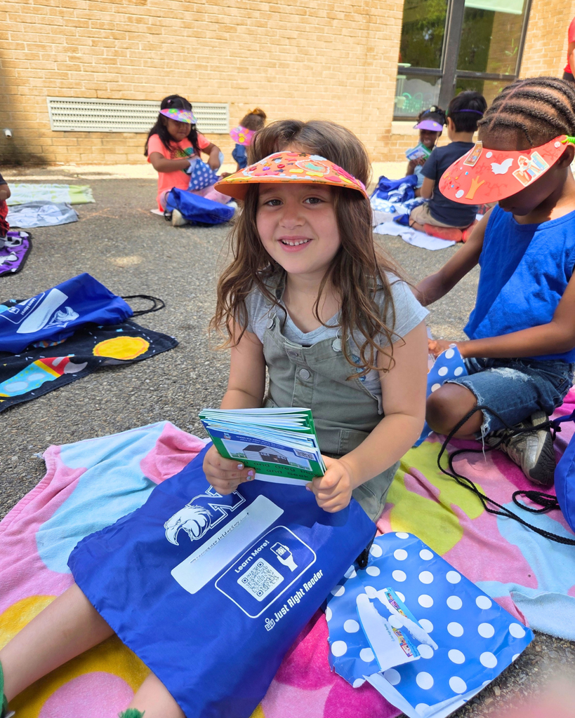 Student smiles for photo sitting outside with her books.