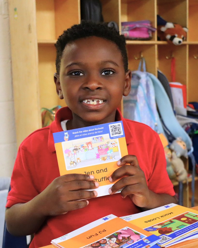 Student holding up one of their decodable books.