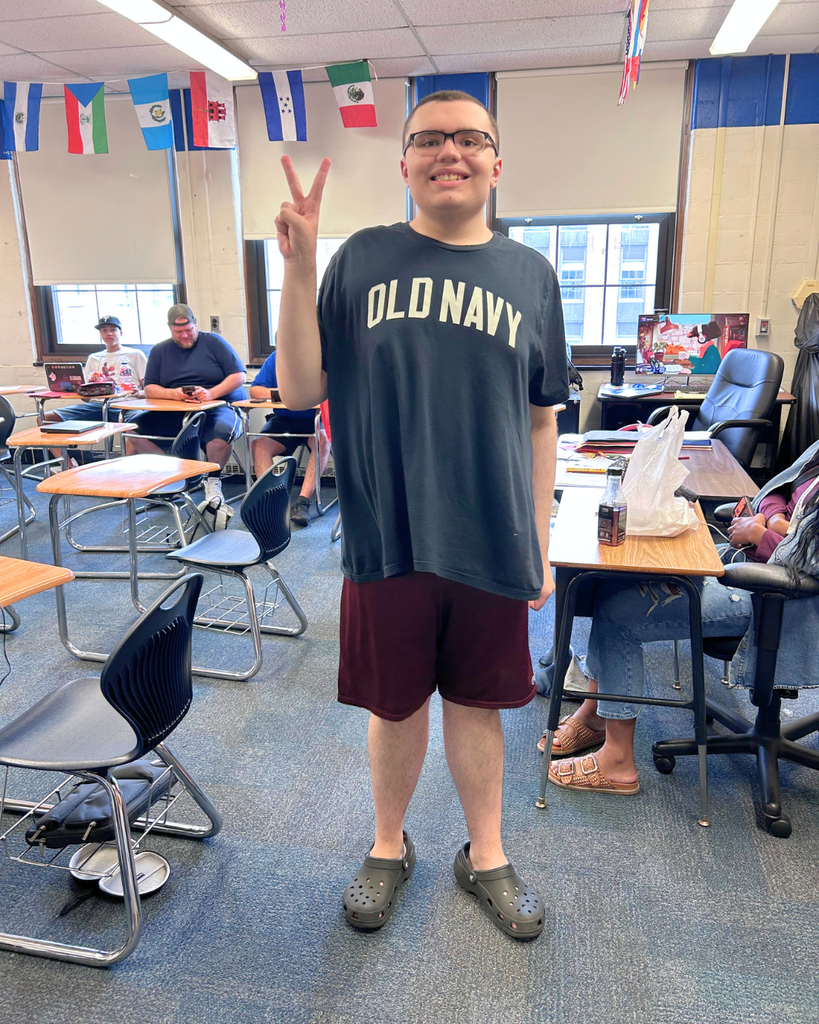 Student poses for photo holding up a peace sign.