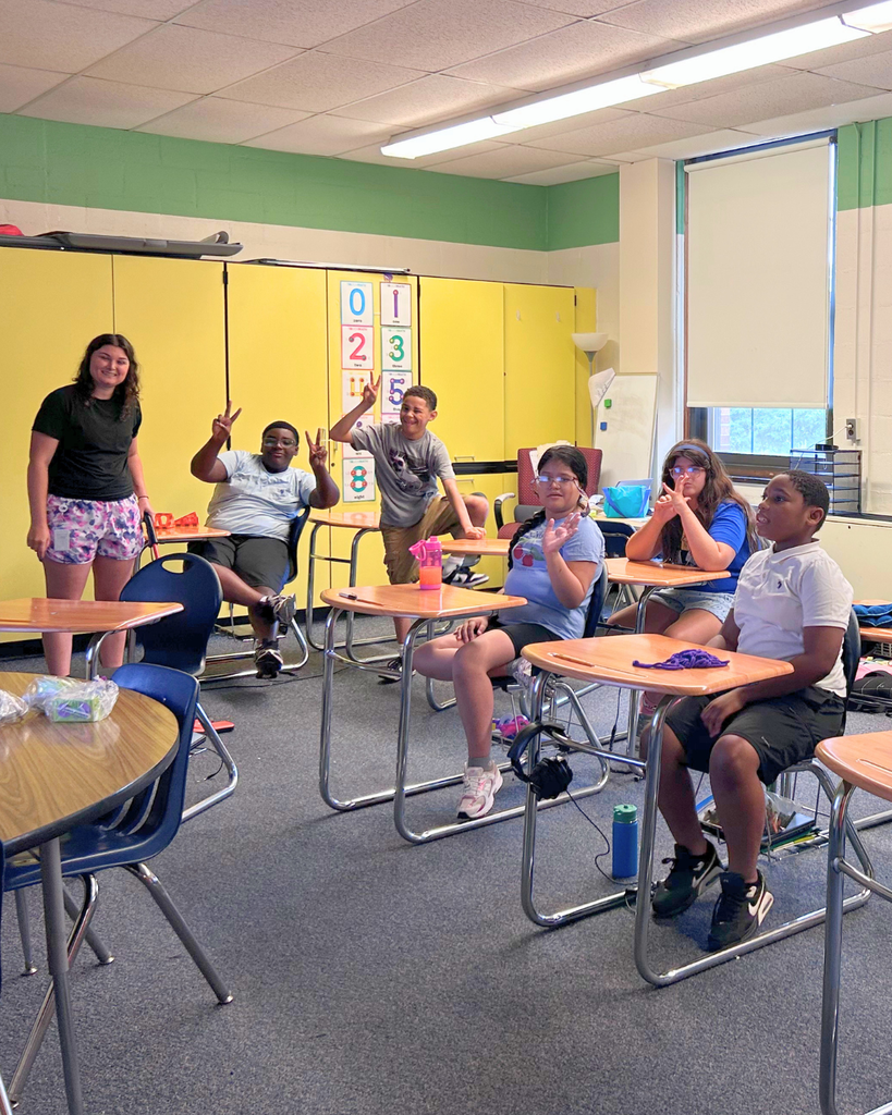 Students and staff smile for a photo in a classroom during ESY.