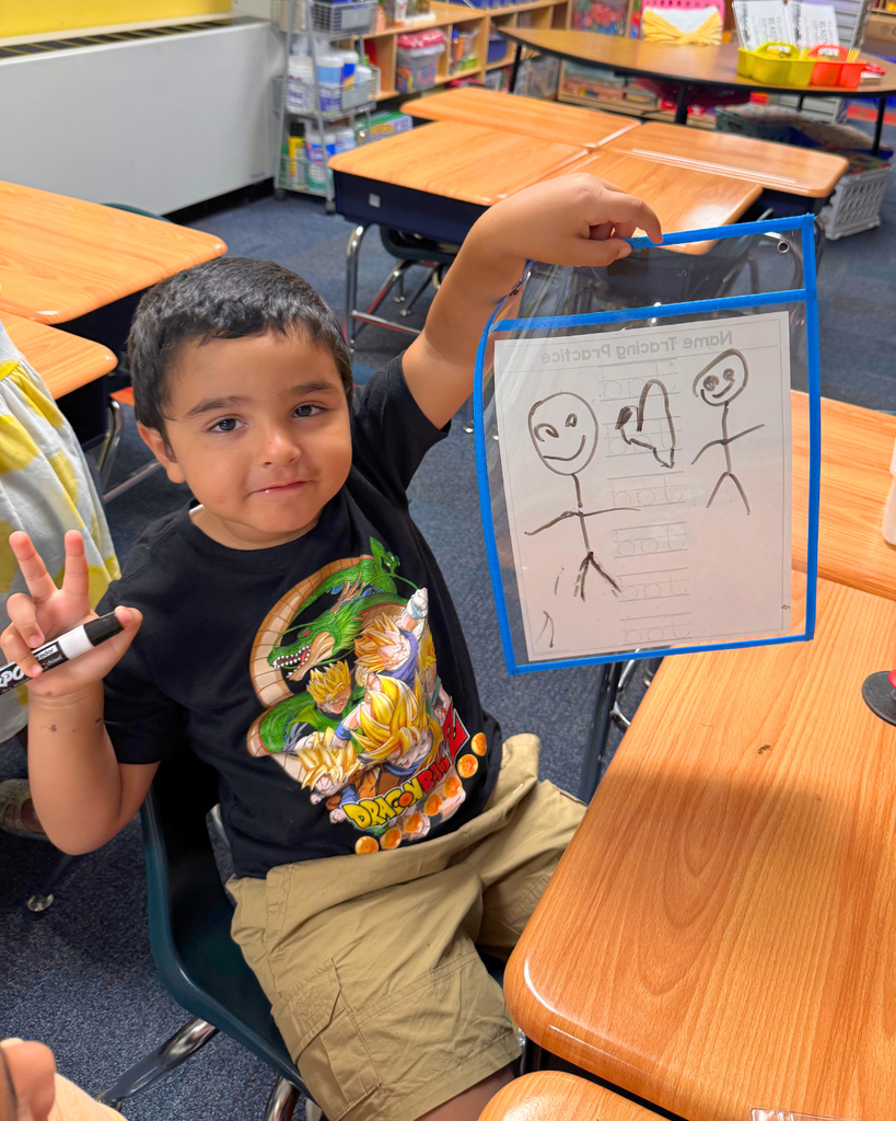 Student holding up their whiteboard with a drawing.