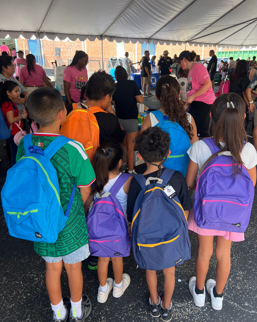 Group of students facing away from the camera showing their brand new backpacks.
