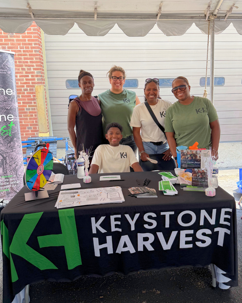 Keystone Harvest team stands behind their table with resources and information.