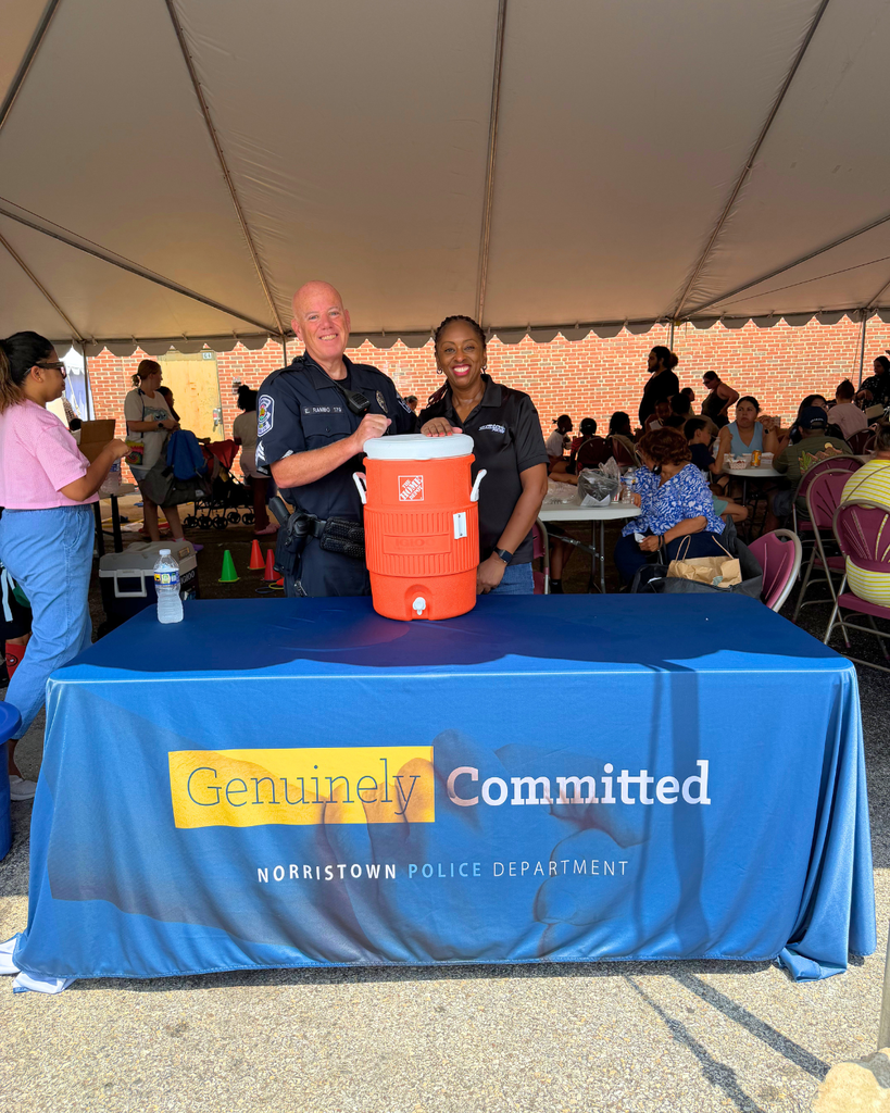 Norristown Police smile for photo behind their table with water ice.
