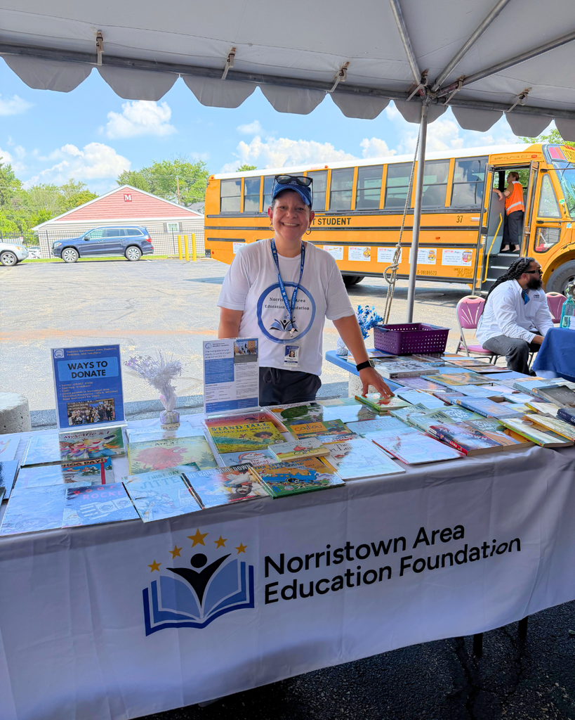 Dr. D'Antonio stands behind her table with free books for students.