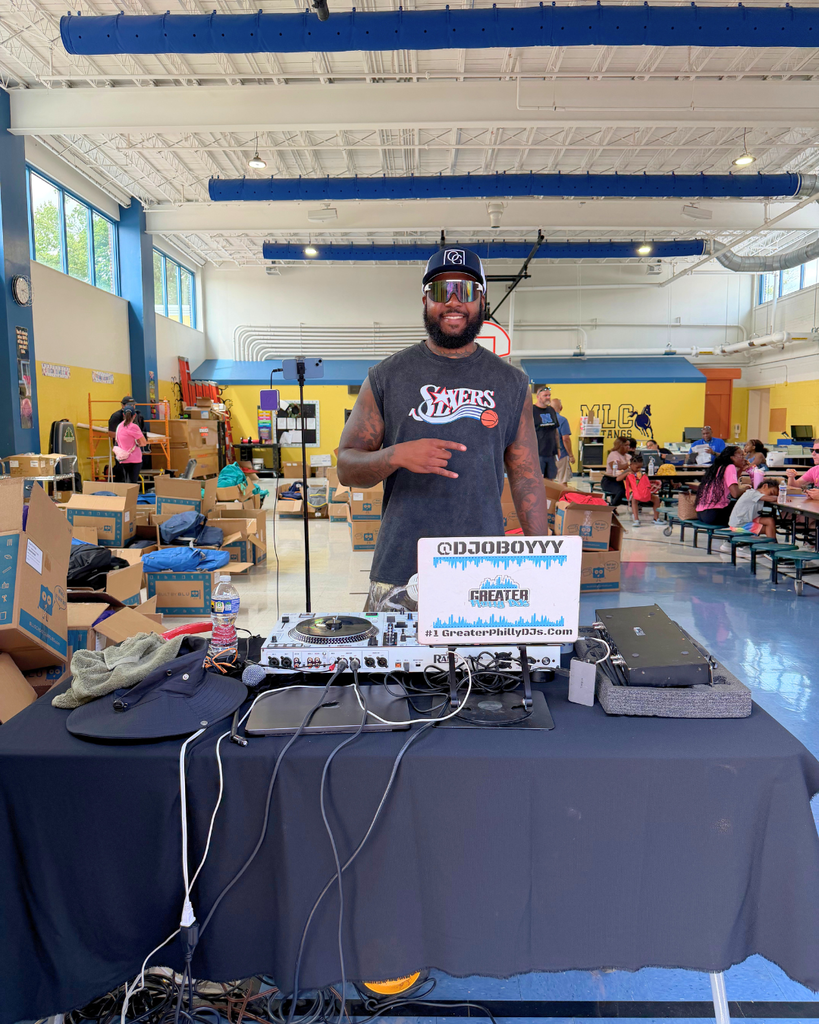 DJ smiles for photo behind his booth.