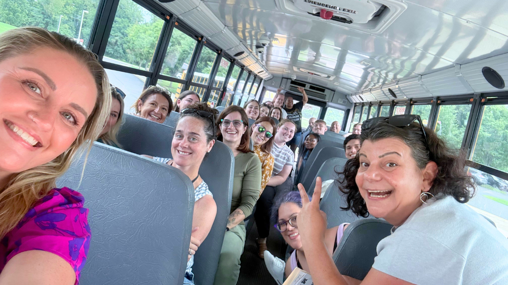 First group of new teacher and bus tour guides take selfie on bus