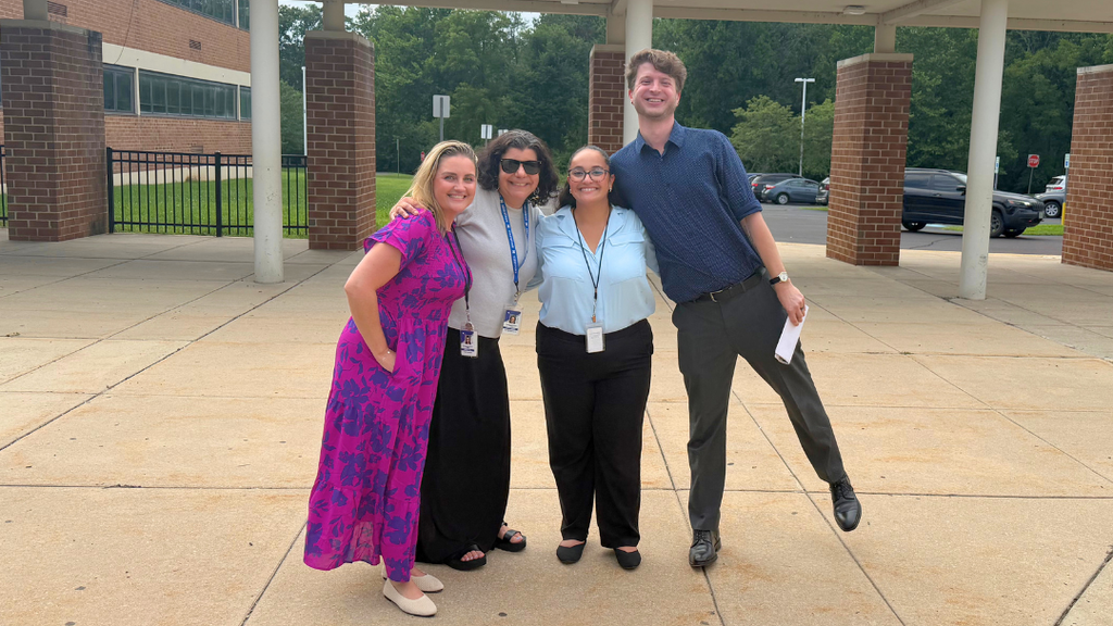 Four tour guides pose for photo together.