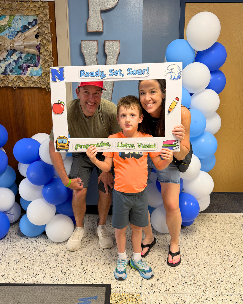 Student and their family pose with poster board frame that says "Ready, Set, Soar!"