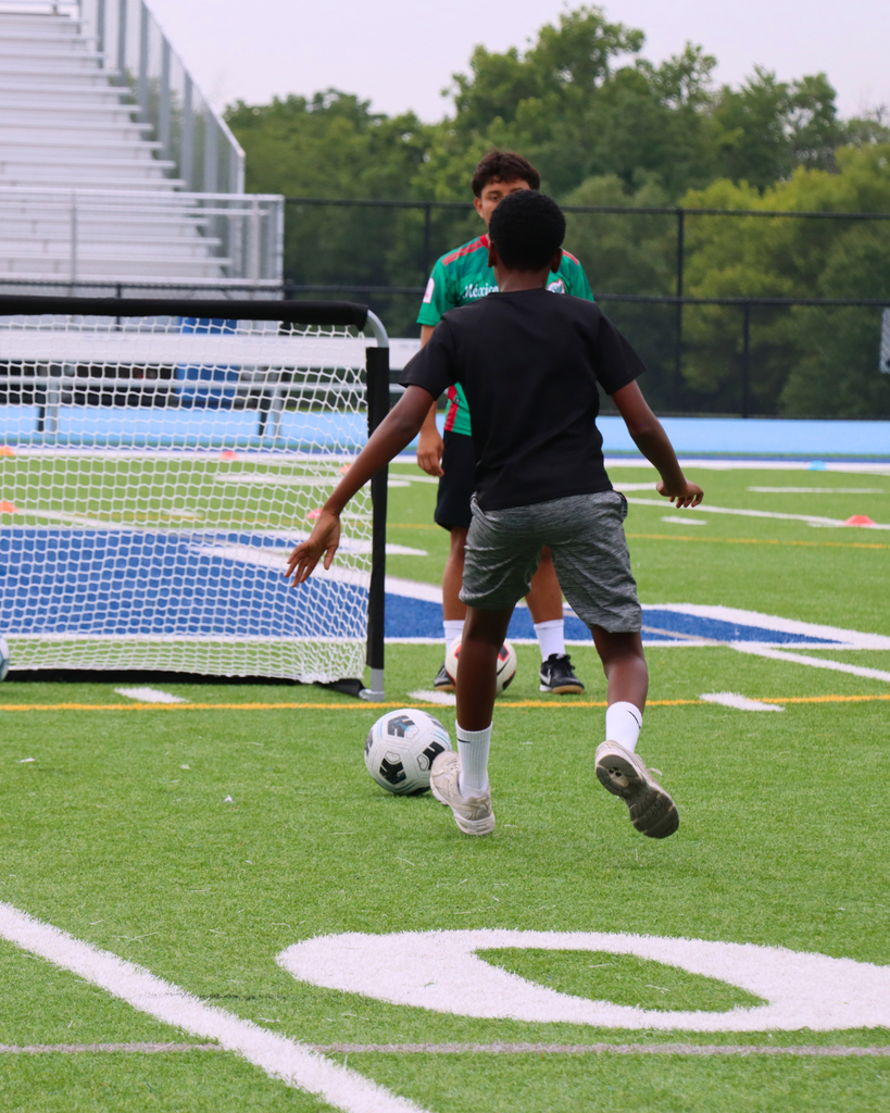 Young player shoots soccer ball towards net.