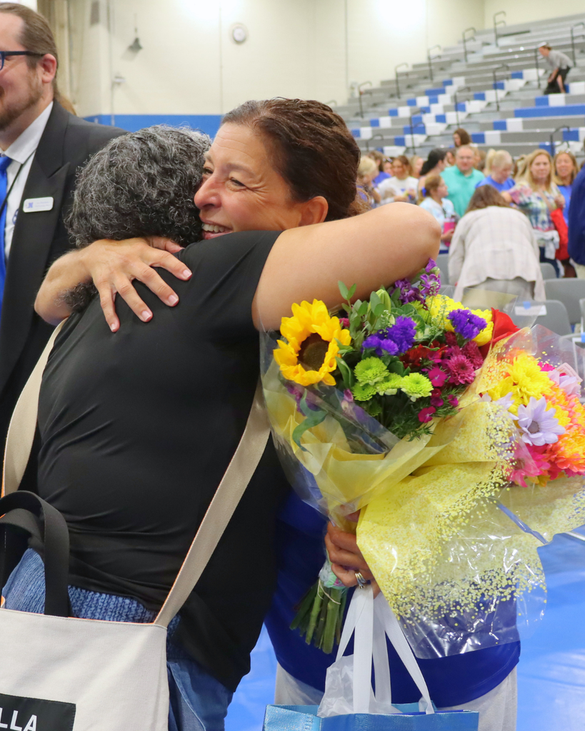 Mrs. Rotondo receives hugs from colleagues.
