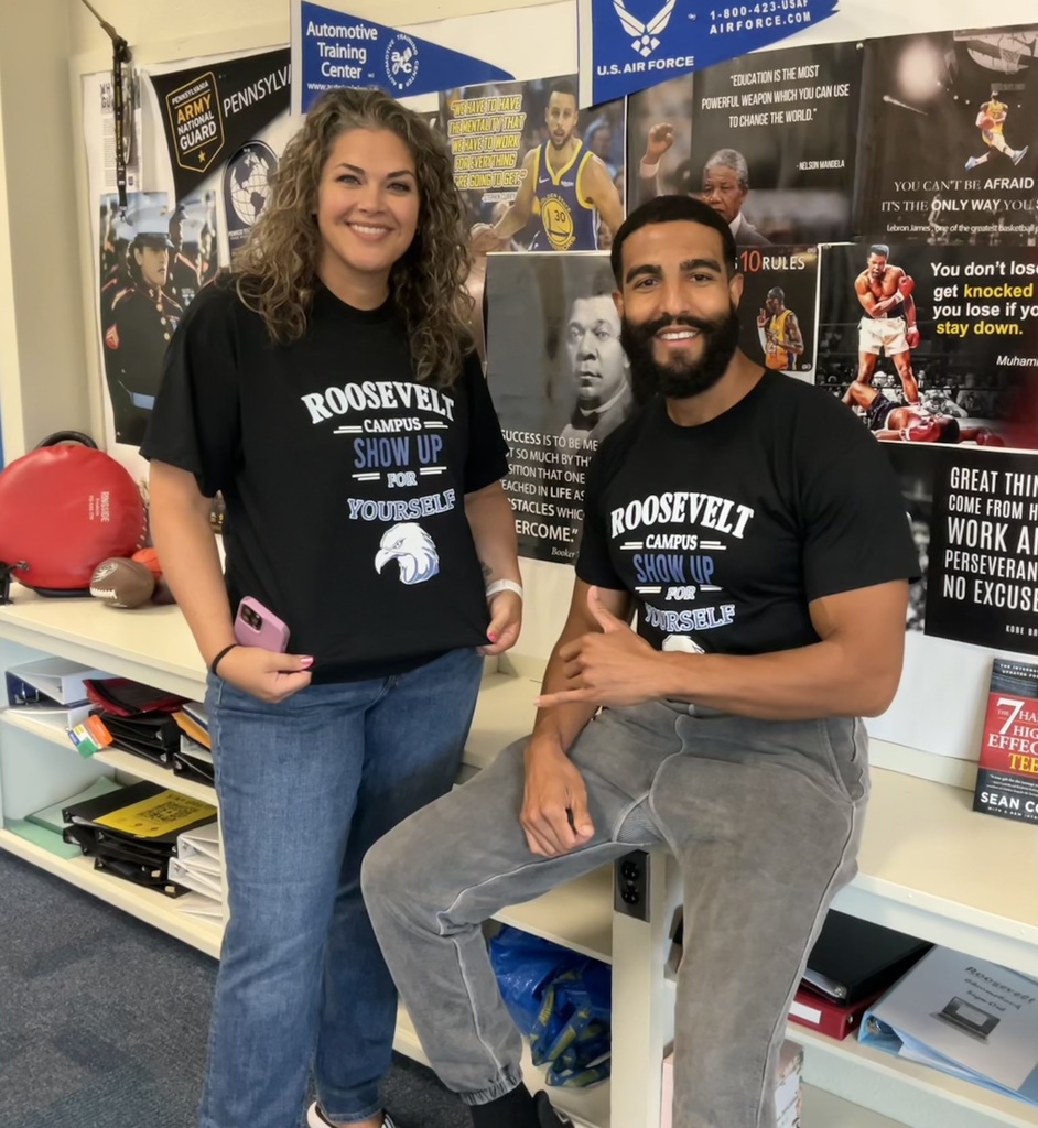 two staff members are posing in the same shirt that represents Roosevelt