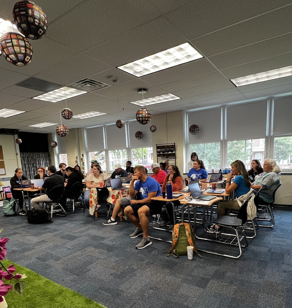 Staff is sitting in a classroom listening to a presentation