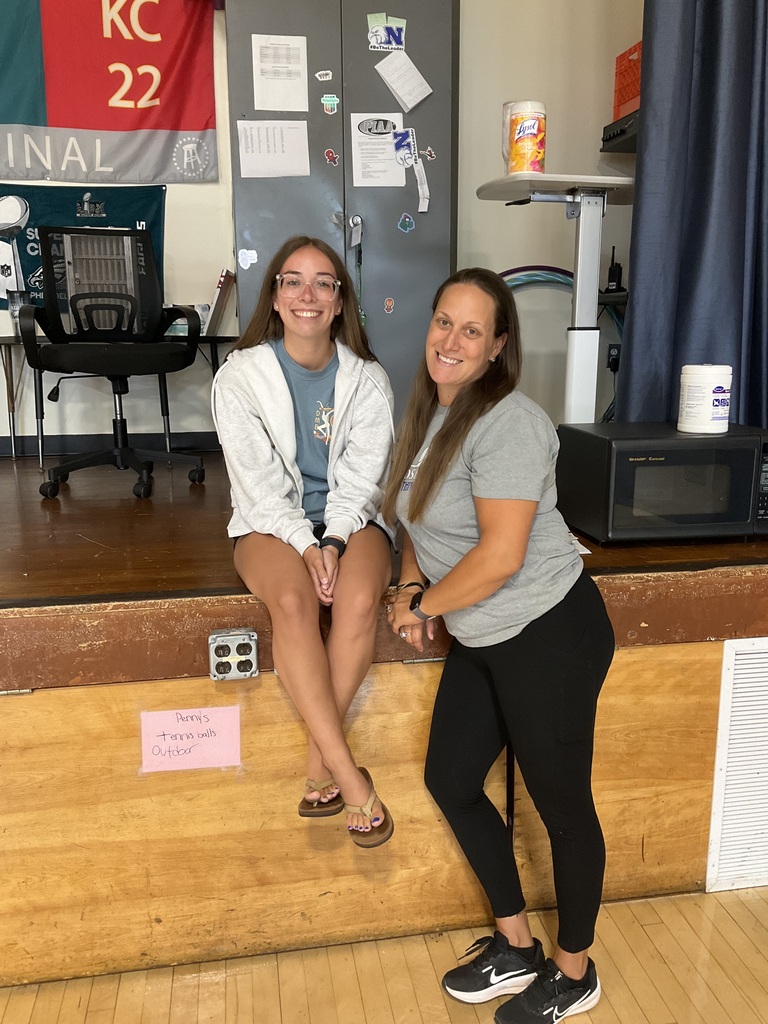 Two teachers are posing for a picture in the gym