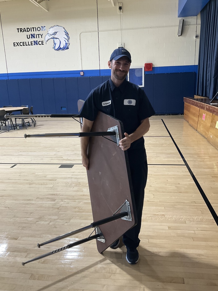 The custodian is moving a table