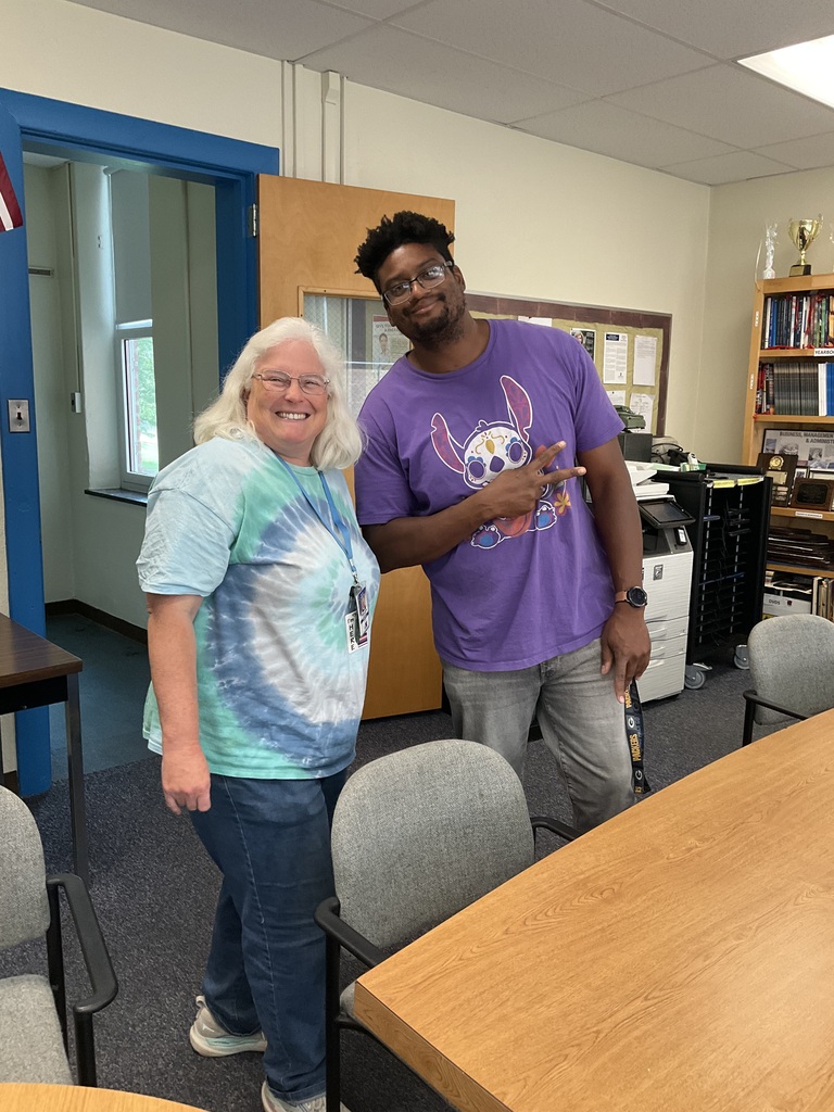 Two teachers are posing in the faculty lounge together