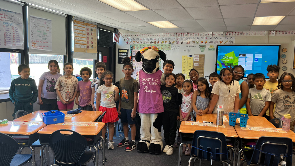 Class of students stand with Chick-fil-a cow mascot.