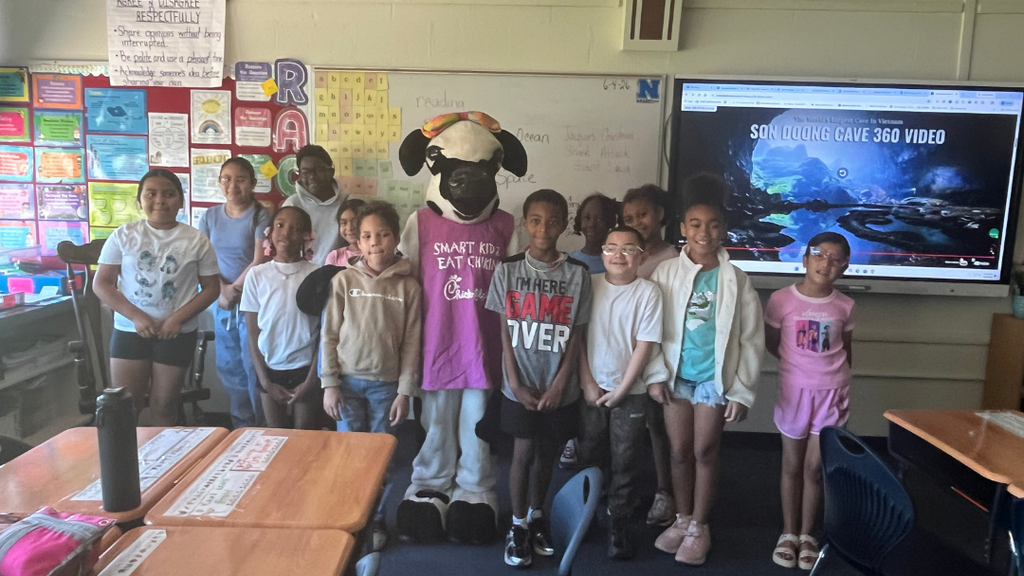 Class of students stand with Chick-fil-a cow mascot.