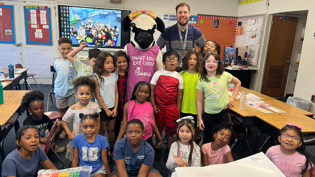 Class of students stand with Chick-fil-a cow mascot.