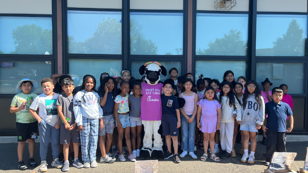 Class of students stand with Chick-fil-a cow mascot.