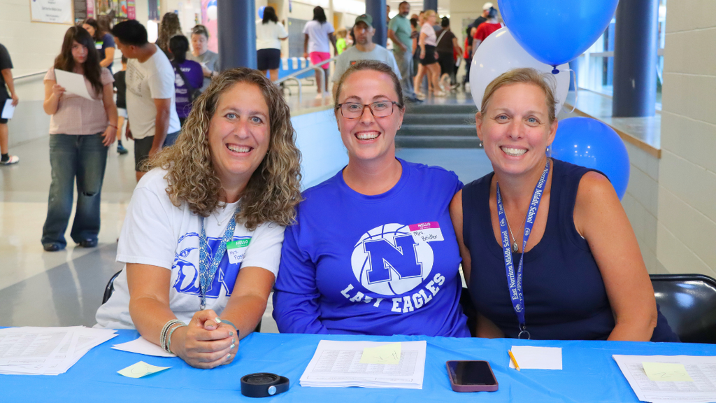 ENMS Teachers sitting at check-in table at their family welcome event.