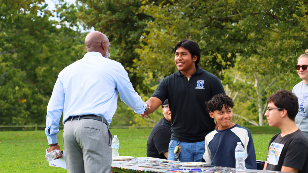 Dr. Green shaking hands with student.