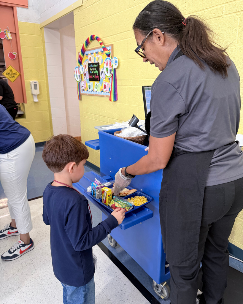 Food service team member helping student at lunch checkout.