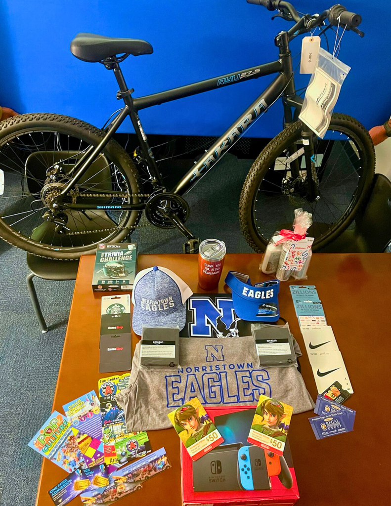 Attendance prizes displayed on table with a bike behind the table.
