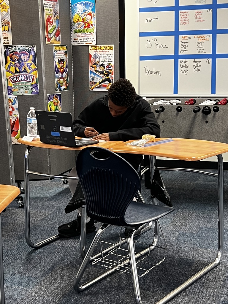 A student is focusing on his work at his desk