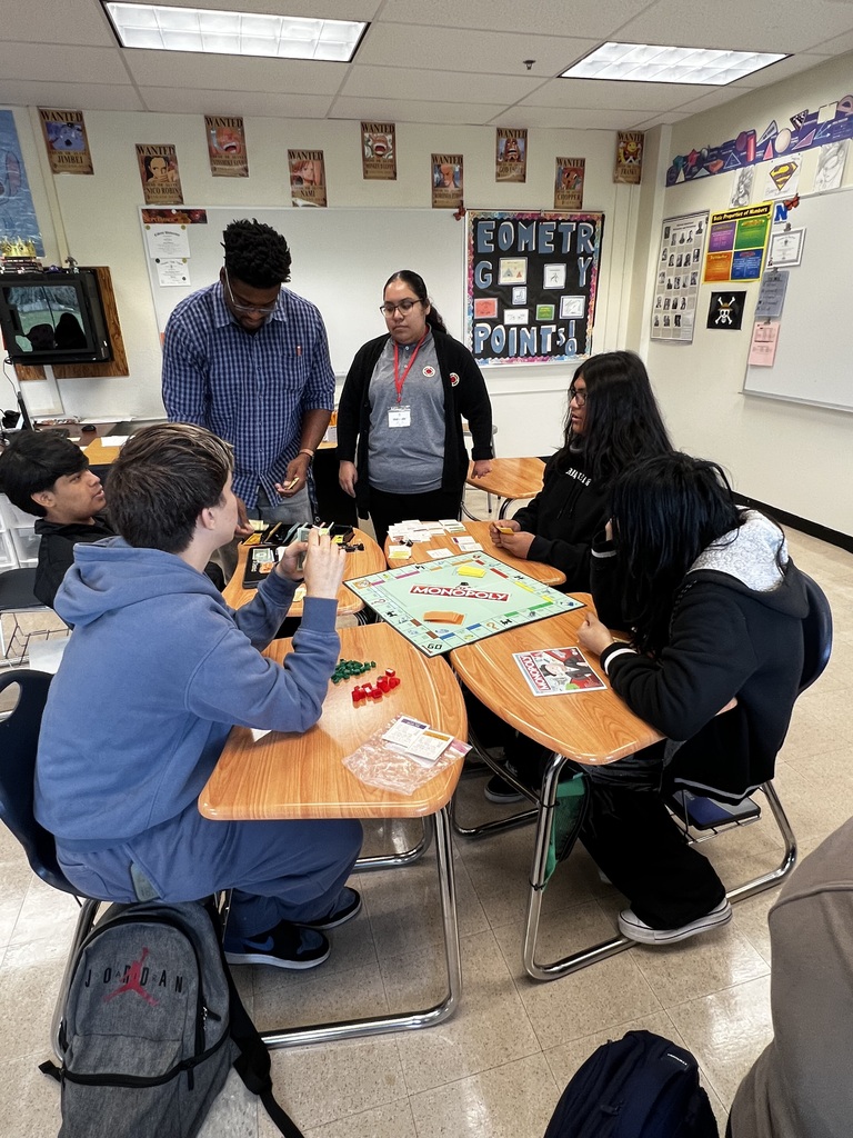 Students and the teacher are playing Monopoly