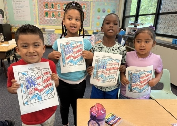 Kindergartners honor Patriot Day with American flags.